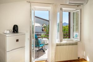 a kitchen with a door open to a balcony with a table and chairs at Double Rooms Jasna with Sea View in Baška