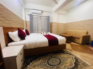 a hotel room with a bed and a chair at Hotel Kandara in Pokhara +21 photos