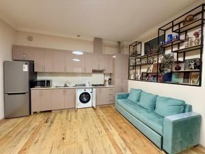 a living room with a blue couch and a kitchen at Ashtarak Garden GuestHouse in Ashtarak