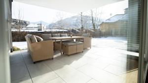 a patio with wicker chairs and a table on a porch at Großzügige Gartenwohnung mit Bergblick in Fritzens