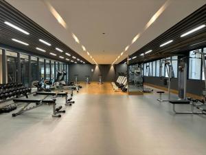 a gym with rows of treadmills and exercise machines at Sunnyplace Residences Near NAIA Airport in Manila