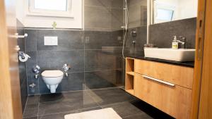a bathroom with a toilet and a sink at Großzügige Gartenwohnung mit Bergblick in Fritzens