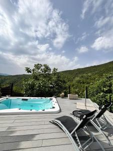 a deck with two chairs and a swimming pool at Sotto il fico in Agnino
