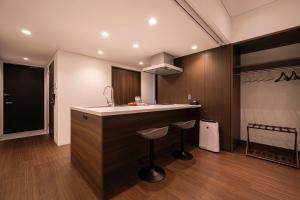 a kitchen with a sink and a counter with stools at Cava House - Vacation STAY 07286v in Tokyo +18 photos
