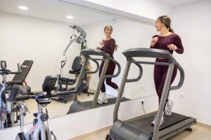a woman walking on a treadmill in a gym at Villa Almy in Plaka