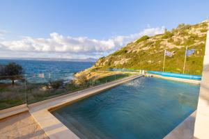 a swimming pool with a view of the ocean at Villa Almy in Plaka