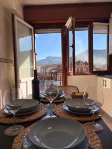 a table with plates and glasses on it with a view at Itxinako Balkoia in Murueta-Orozko