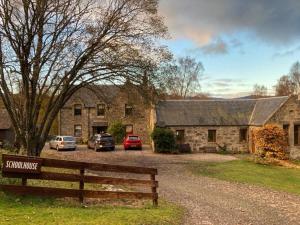 a stone house with cars parked in front of it at Old School in Kingussie