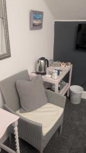 a room with a chair and a table with a tea kettle at The Bridges B&B in Broomhill