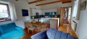 a living room with a blue couch and a table at Old School in Kingussie