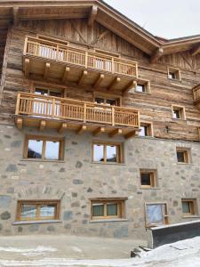 ein Blockhaus mit einem Balkon an der Seite in der Unterkunft I Cavezàl in Valdisotto