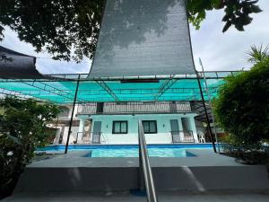 a building with a swimming pool in front of it at Resort safari hot spring in Calamba