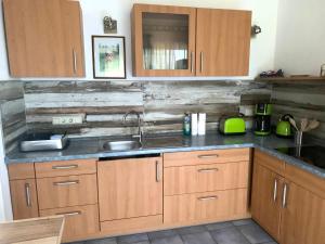 a kitchen with wooden cabinets and a sink at Pension Horn in Schkopau