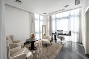 a living room with white furniture and a table and chairs at Leonardo Boutique Hotel Tel Aviv in Tel Aviv +80 photos