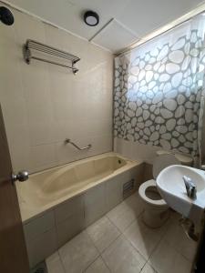 a bathroom with a tub and a toilet and a sink at MyPlace Sri Cemerlang Kota Bharu in Kota Bharu +24 photos