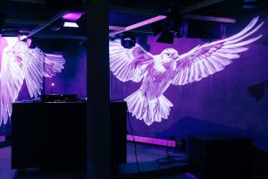 a purple room with a bird flying in the air at The Suites in St. Moritz