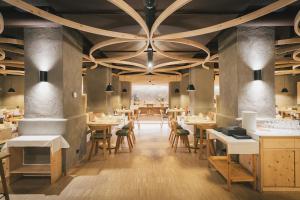 a restaurant with wooden tables and chairs and a large ceiling at The Suites in St. Moritz +37 photos