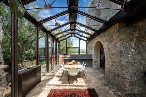 a glass conservatory with a table and chairs at Castello Di Vicarello in Sasso dʼOmbrone