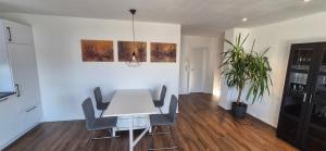 a dining room with a white table and chairs at Neckartalblick in Nürtingen