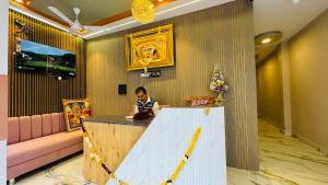 a person sitting at a counter in a room at Hotel Shri Kaila Devi in Ujjain