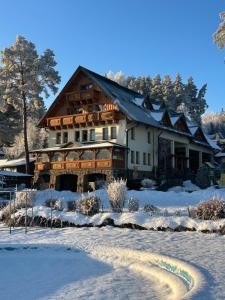 a large house in the snow with a trail at Slanický Dvor in Námestovo