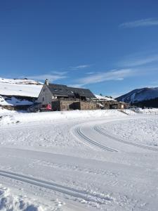 a house in the snow with tracks in the snow at Gîte Le Logis des Dieux in Sarrancolin