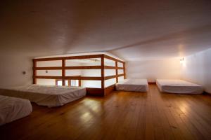 a room with two beds and a wooden floor at Gîte Le Logis des Dieux in Sarrancolin