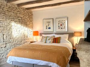 a bedroom with a bed and a stone wall at La Cour des Délices in Gigny +48 photos