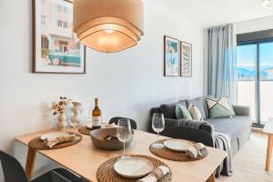 a living room with a table and a couch at Las Dunas 215 - by Welcomely in Oliva +26 photos