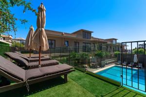 a swimming pool with a patio umbrella and a swimming pool at Mariette Rhodes Urban Suites in Rhodes Town