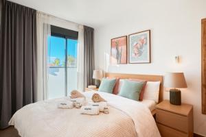 a bedroom with a large bed with towels on it at Las Dunas 215 - by Welcomely in Oliva