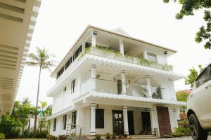 a white building with a balcony and palm trees at Dreamland View Resort in Cochin