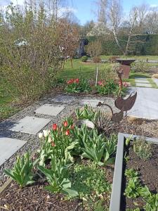a garden with flowers and a statue in the middle at Chez Marianne in Hotton +4 photos