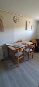 a table and chairs in a room with a clock at Chez Marianne in Hotton