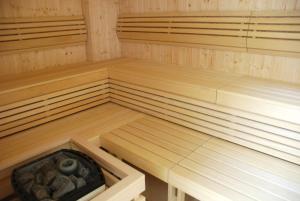 an empty sauna with wooden benches and a bowl in it at Zespół Dolina Białego - Pensjonat Biały Potok in Zakopane