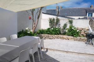 a dining room with a table and white chairs at Village du Manémeur in Quiberon
