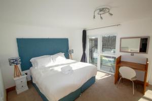 a bedroom with a bed and a desk and a window at Waves Guest Suites in Castel