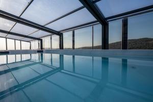 a swimming pool in a house with glass windows at Naomi Boutique Suites in Netu'a +63 photos
