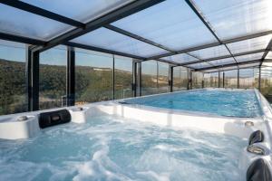 a hot tub in a glass house with a view at Naomi Boutique Suites in Netu'a
