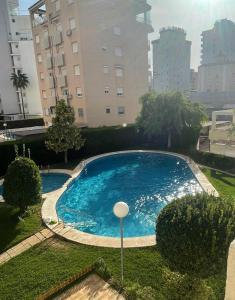 a large blue swimming pool in the middle of a city at Terraza Soleada in Puerto de Gandía