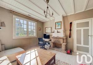 a living room with a table and a desk with a computer at Exceptional beach sea view in Plestin-les-Grèves