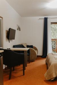 a living room with a couch and a table and a tv at Holiday Family Pod Świerkami centrum miasta! in Szklarska Poręba