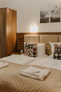a hotel room with two beds with towels on them at Holiday Family Pod Świerkami centrum miasta! in Szklarska Poręba
