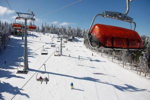 a ski lift with people on a snow covered slope at Wellness Hostel Polskie Wrota in Lewin Kłodzki
