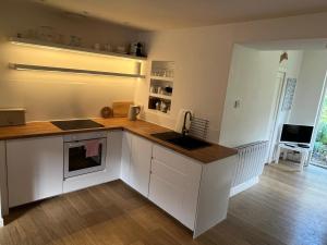 a kitchen with white cabinets and a counter top at 4 Balvaig Cottage, Strathyre in Stirling +10 photos