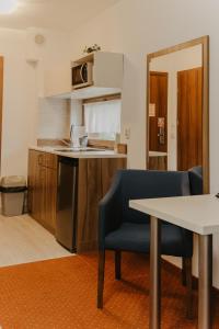 a small kitchen with a table and a blue chair at Holiday Family Pod Świerkami centrum miasta! in Szklarska Poręba