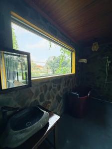 a bathroom with a stone sink and a window at Trang An Mountain Ecologe in Xuân Sơn