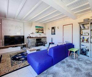 a living room with a blue couch and a fireplace at Exceptional beach sea view in Plestin-les-Grèves