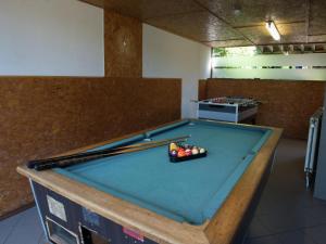a pool table with two cuesticks on top of it at Cottage in the heart of the Ardennes in Waimes +26 photos