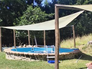 a white canopy over a pool with a table at Modrá chalúpka in Kremnica